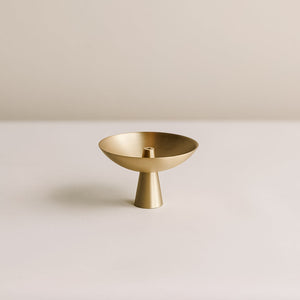 A matte brass incense holder with a timeless design, featuring a unique shape with a central holder for incense.