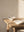 Incense stick burning in a white bowl on a wooden table with an open book.